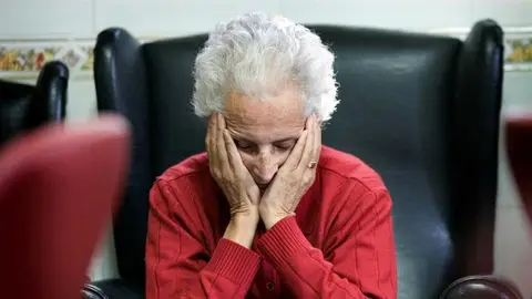 Una mujer descansa en la sala de estar de un centro de día Una mujer descansa en la sala de estar de un centro de día