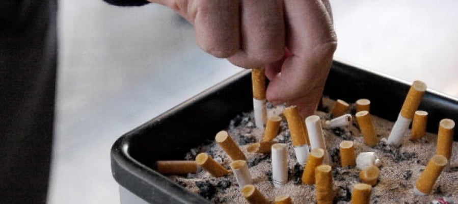 Un fumador apaga un cigarrillo Un fumador apaga un cigarrillo