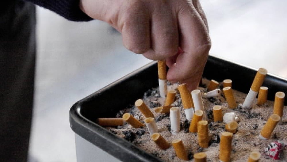 Un fumador apaga un cigarrillo