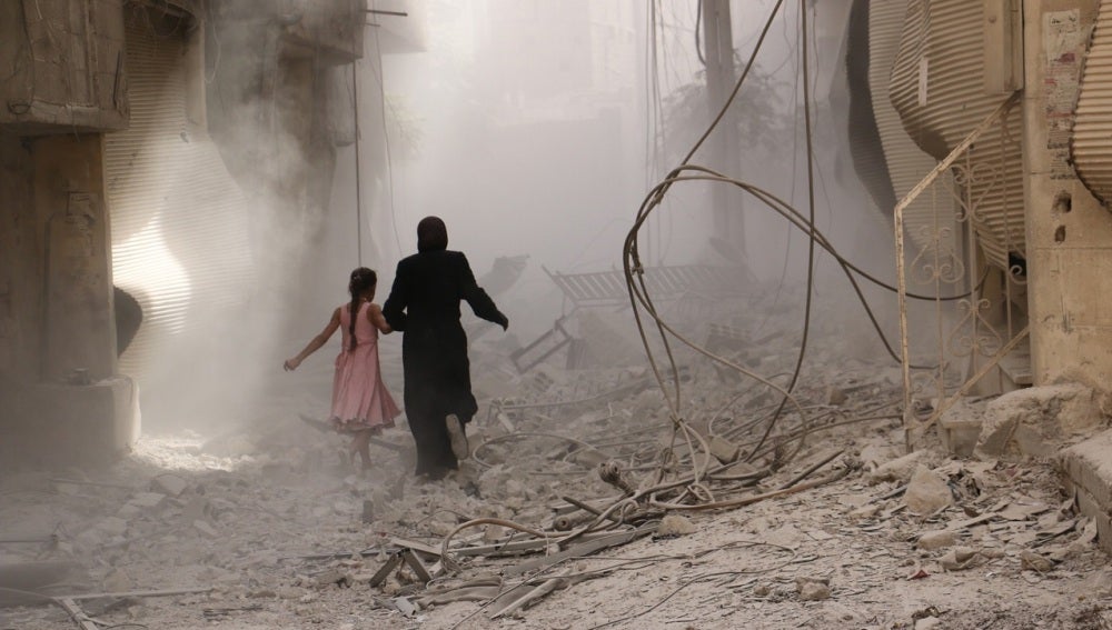 Una mujer y su hija caminan entre las ruinas en SiriaUna mujer y su hija caminan entre las ruinas en Siria