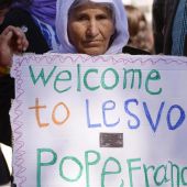 Una mujer porta una pancarta para recibir al Papa Francisco