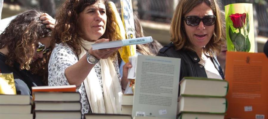 Mujeres con un libro y una rosa para celebrar Sant Jordi Mujeres con un libro y una rosa para celebrar Sant Jordi