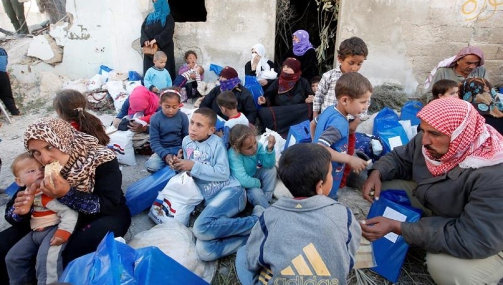 Familias sirias esperan la entrega de ayuda humanitaria