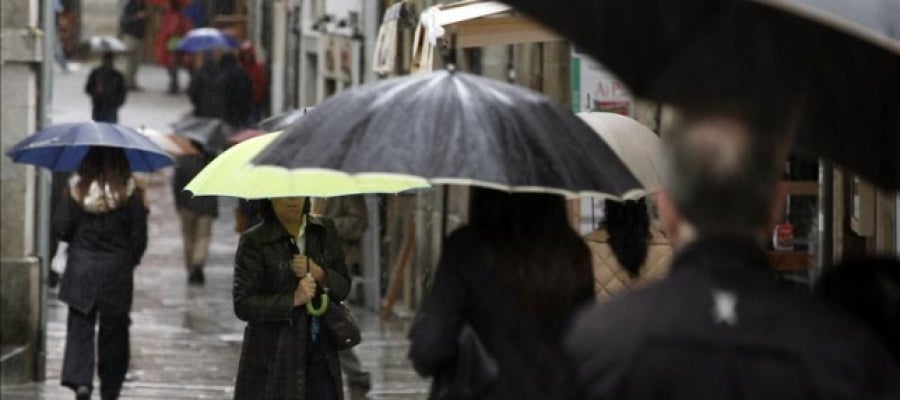 Varias personas se protegen de la lluvia con paraguas Varias personas se protegen de la lluvia con paraguas