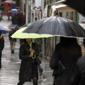 Varias personas se protegen de la lluvia con paraguas Varias personas se protegen de la lluvia con paraguas
