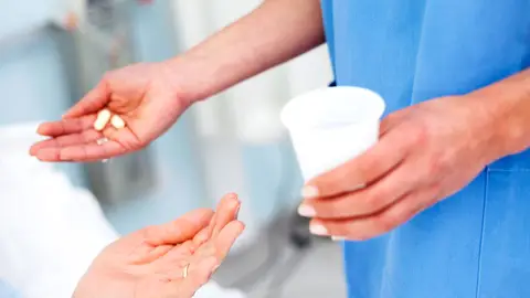 Una enfermera dando la medicación Una enfermera dando la medicación