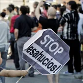 Un niño sostiene un cartel de Stop desahucios, en una imagen de archivo. Un niño sostiene un cartel de Stop desahucios, en una imagen de archivo.