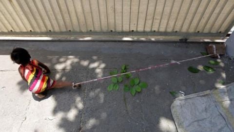 La ni&ntilde;a que pasa el d&iacute;a atada a una piedra mientras sus padres trabajan