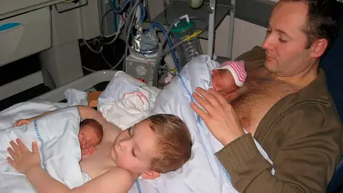 Un niño y su padre practican el 'piel con piel' Un niño y su padre practican el 'piel con piel'