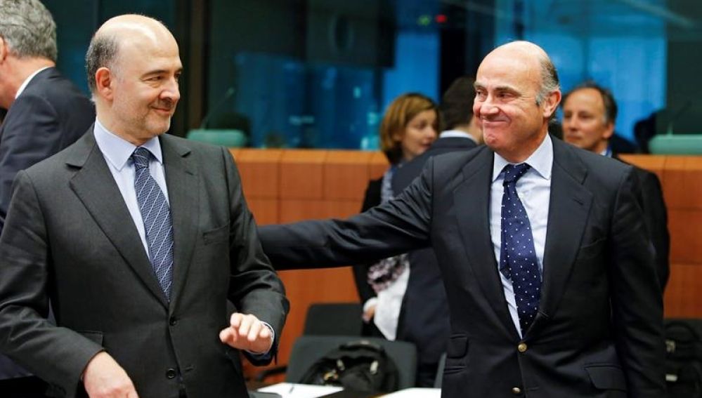 El comisario europeo de Asuntos Económicos, Pierre Moscovici, (i), conversa con el ministro español en funciones de Economía, Luis de Guindos