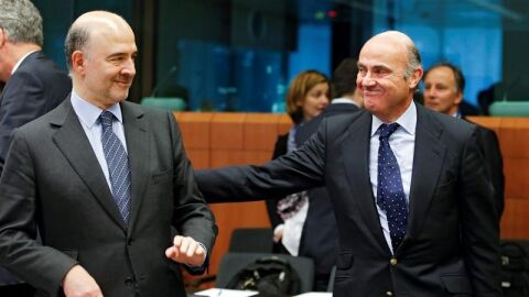 El comisario europeo de Asuntos Econ&oacute;micos, Pierre Moscovici, (i), conversa con el ministro espa&ntilde;ol en funciones de Econom&iacute;a, Luis de Guindos