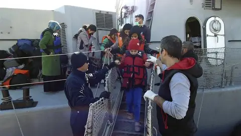 Inmigrantes y refugiados bajan de un bote del servicio de guardacostas griego tras ser rescatados Inmigrantes y refugiados bajan de un bote del servicio de guardacostas griego tras ser rescatados