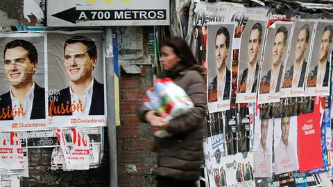 Una mujer pasa por una calle con los carteles de Albert Rivera. Una mujer pasa por una calle con los carteles de Albert Rivera.