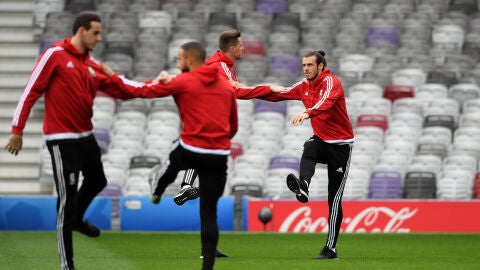 Gareth Bale calienta junto a sus compa&ntilde;eros de Gales