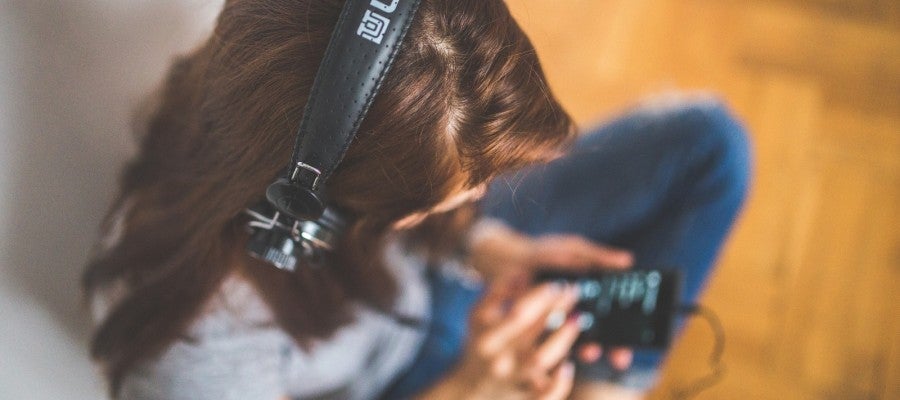 Una mujer escuchando con auriculares Una mujer escuchando con auriculares