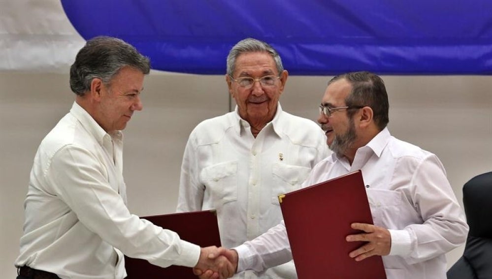 El líder de las FARC en Cuba, Rodrigo Londoño alias "Timochenko" y el presidente de Colombia, Juan Manuel Santos, junto al presidente de Cuba, Raúl Castro
