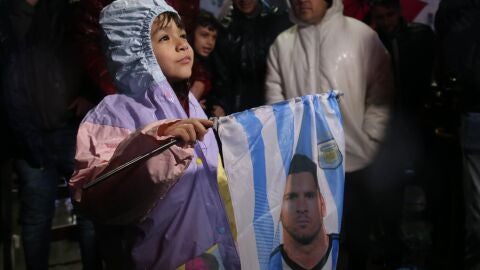Un ni&ntilde;o sostiene una bandera con la cara de Leo Messi