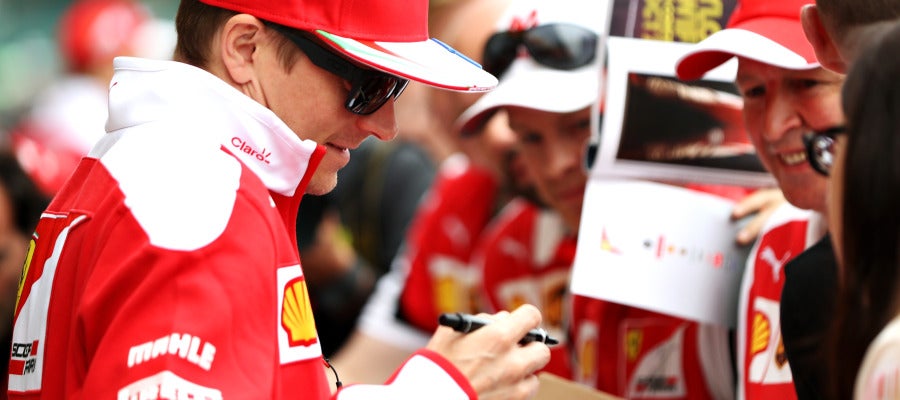 Kimi Raikkonen firma un autógrafo a un aficionado Kimi Raikkonen firma un autógrafo a un aficionado