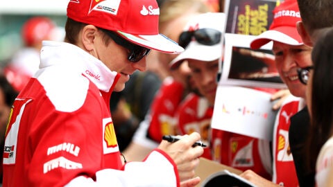 Kimi Raikkonen firma un aut&oacute;grafo a un aficionado