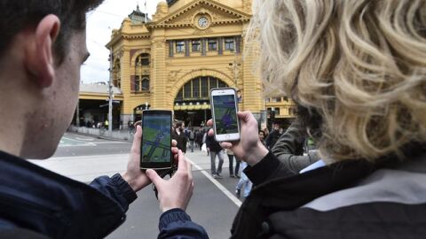  Dos estudiantes prueban el nuevo juego 'Pok&eacute;mon Go' en su m&oacute;vil 