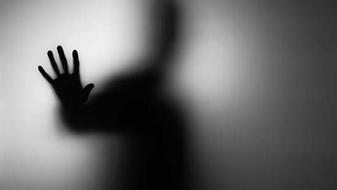 Una persona apoya su mano en el cristal