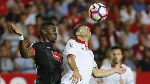 El delantero del Sevilla, Luciano Vietto, salta por el bal&oacute;n con el senegal&eacute;s Pape Diop, del Espanyol