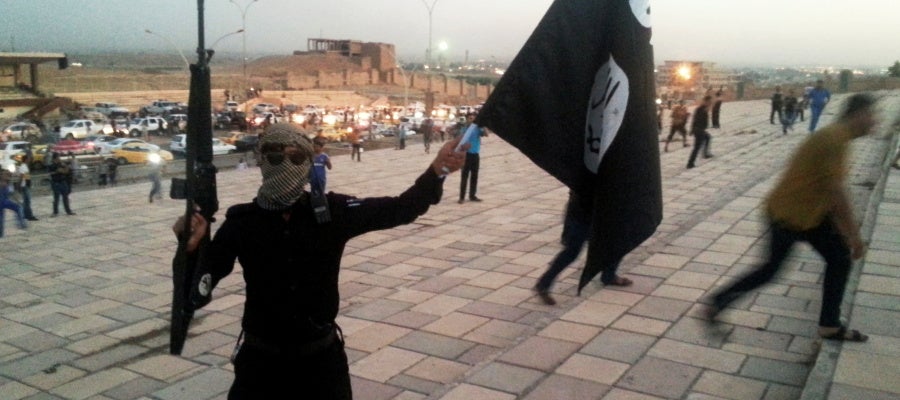 Un combatiente de Daesh sostiene una bandera y un arma en una calle de Mosul Un combatiente de Daesh sostiene una bandera y un arma en una calle de Mosul