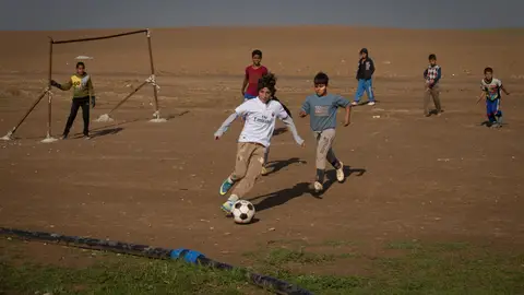 Niños jugando a fútbol en un campo de refugiados del norte de Irak Niños jugando a fútbol en un campo de refugiados del norte de Irak