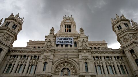Detalle de una pancarta con la leyenda "Refugees Welcome" -"Refugiados, bienvenidos", colocada en la fachada del Palacio de Cibeles