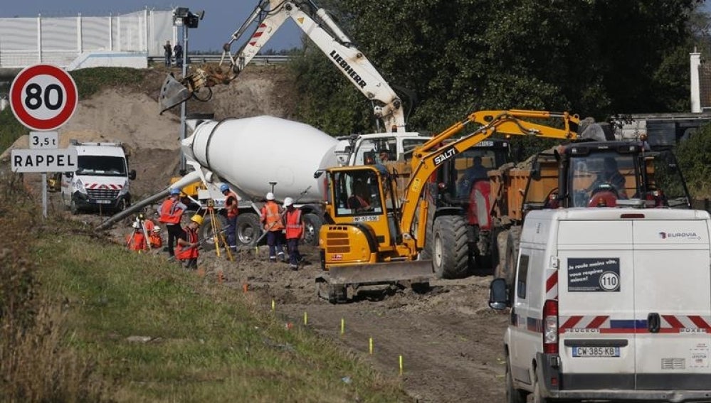 Un grupo de operarios trabajan en la construcción de un muro en la ciudad septentrional francesa de Calais, Francia
