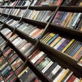 Un hombre ojea varios libros en una librería