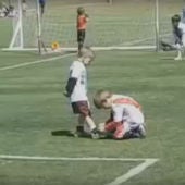 Un niño ayuda a otro a atarse la bota durante un partido en Argentina