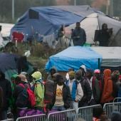 Varios migrantes esperan para su evacuación en el centro de recepción de corta estancia en el campamento conocido como "La Jungla" durante su desmantelamiento en Calais