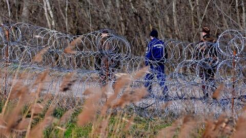 Polic&iacute;as y soldados h&uacute;ngaros patrullan junto a la valla temporal que separa la frontera entre Serbia y Hungr&iacute;a