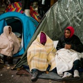 Inmigrantes esperan en sus tiendas de campaña antes del desalojo de un campamento en el distrito 19 de París, Francia