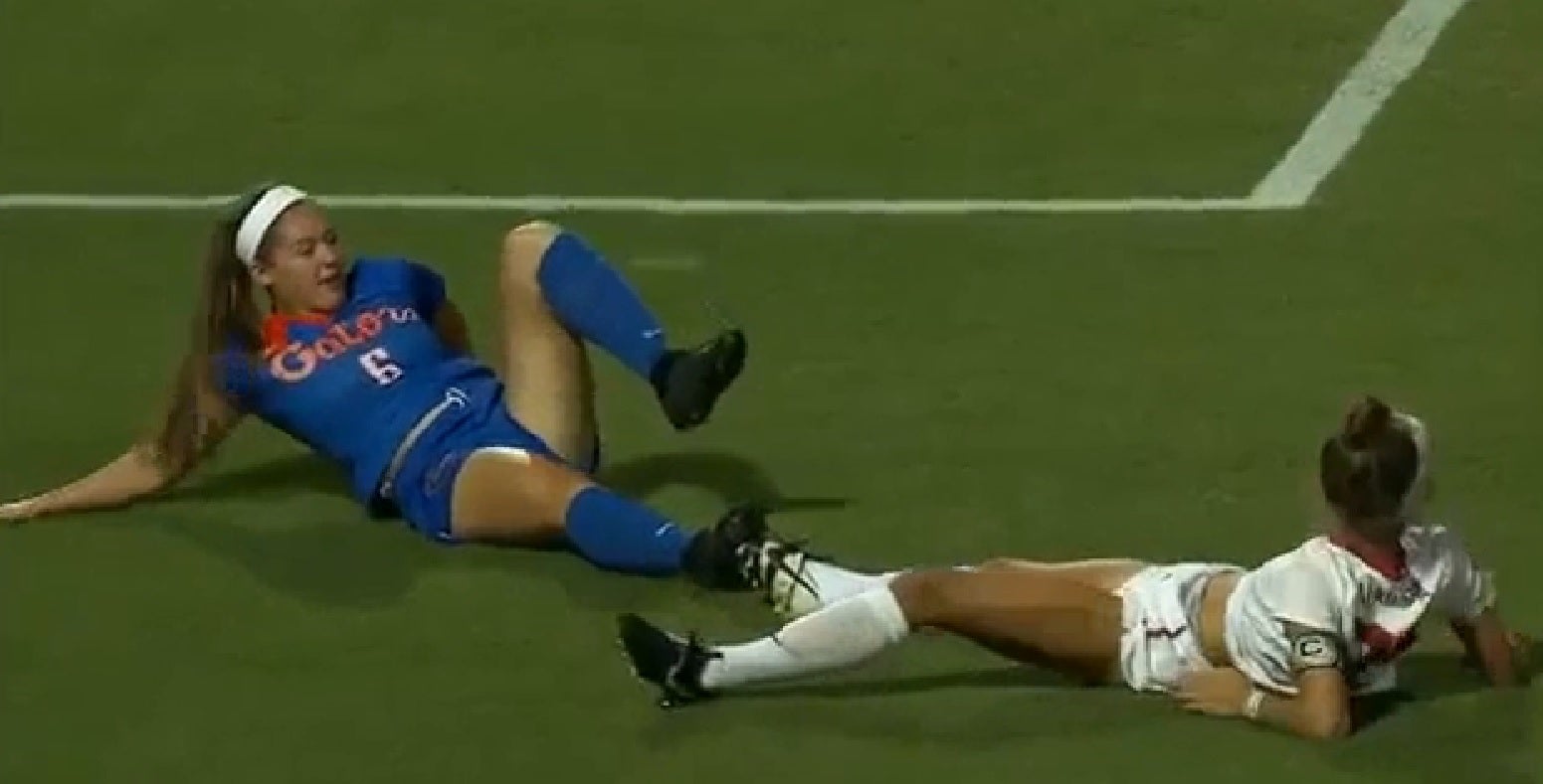 Dos jugadoras de fútbol acaban por el suelo tras quedar enganchadas por los cordones de sus botas Dos jugadoras de fútbol acaban por el suelo tras quedar enganchadas por los cordones de sus botas