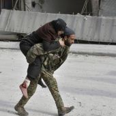 Un soldado sirio trasladando a una mujer herida en Alepo