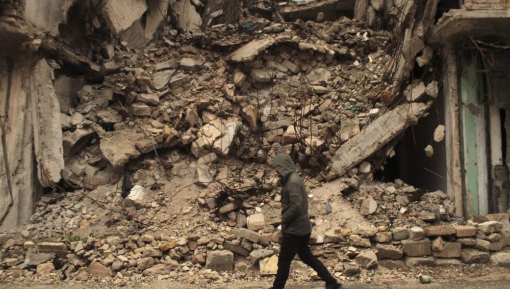 Un hombre camina junto a un edificio derruido en el barrio de al-Mashad en la zona controlada por los rebeldes 