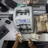 Trabajadoras de un banco cuentan billetes de 100 Bolívares en Caracas (Venezuela)