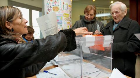 Un hombre deposita su papeleta en la urna de una de las mesas instaladas en un colegio electoral del barrio del eixample barcelon&eacute;s