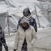 Varios refugiados caminan bajo la nieve en el campamento de refugiados de Moria