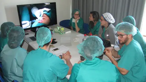 Alumnos del curso siguen la intervención quirúrgica en directo desde una sala. Sanidad