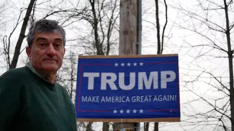 Guillermo Fessr en Estados Unidos junto a un cartel electoral de Donald Trump Guillermo Fessr en Estados Unidos junto a un cartel electoral de Donald Trump