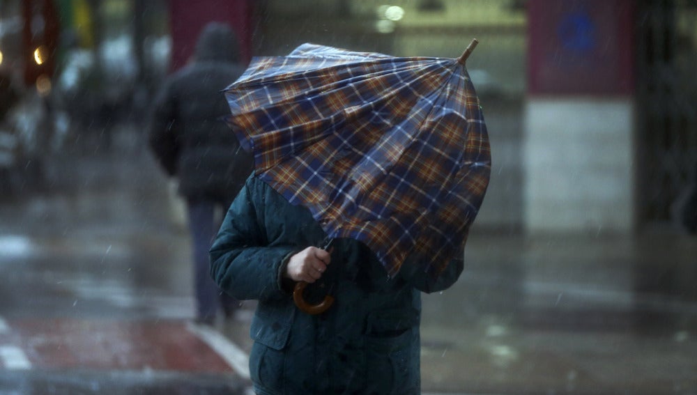 Una persona intenta taparse con un paraguas