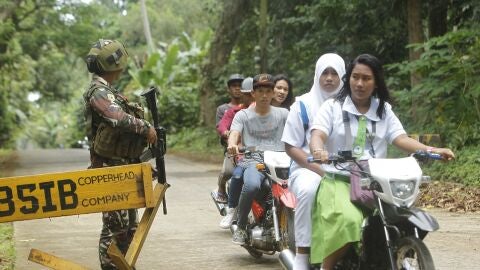  Varios residentes cruzan en moto un punto de control en la provincia de Sulu, al sur de Filipinas