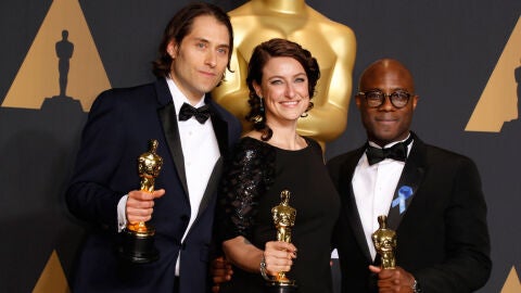 Jeremy Kleiner, Adele Romanski, y el director Barry Jenkins, sostienen el &Oacute;scar a Mejor Pel&iacute;cula por 'Moonlight'