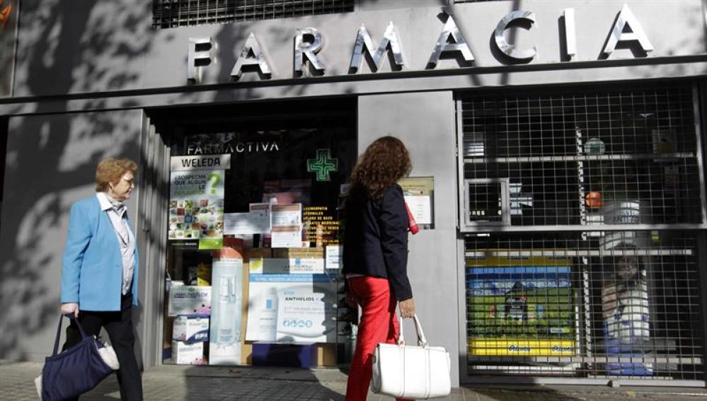 Una mujer pasa por una farmacia en el centro de Barcelona