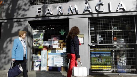 Una mujer pasa por una farmacia en el centro de Barcelona
