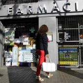 Una mujer pasa por una farmacia en el centro de Barcelona