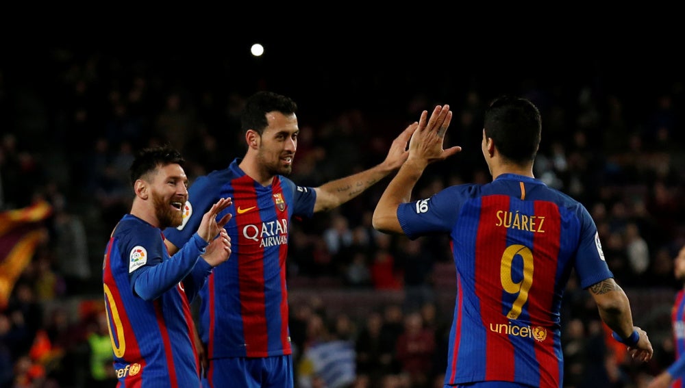 Messi, Busquets y Luis Suárez celebran un gol ante el Sporting